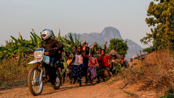 Children chasing a motorbike, Africa