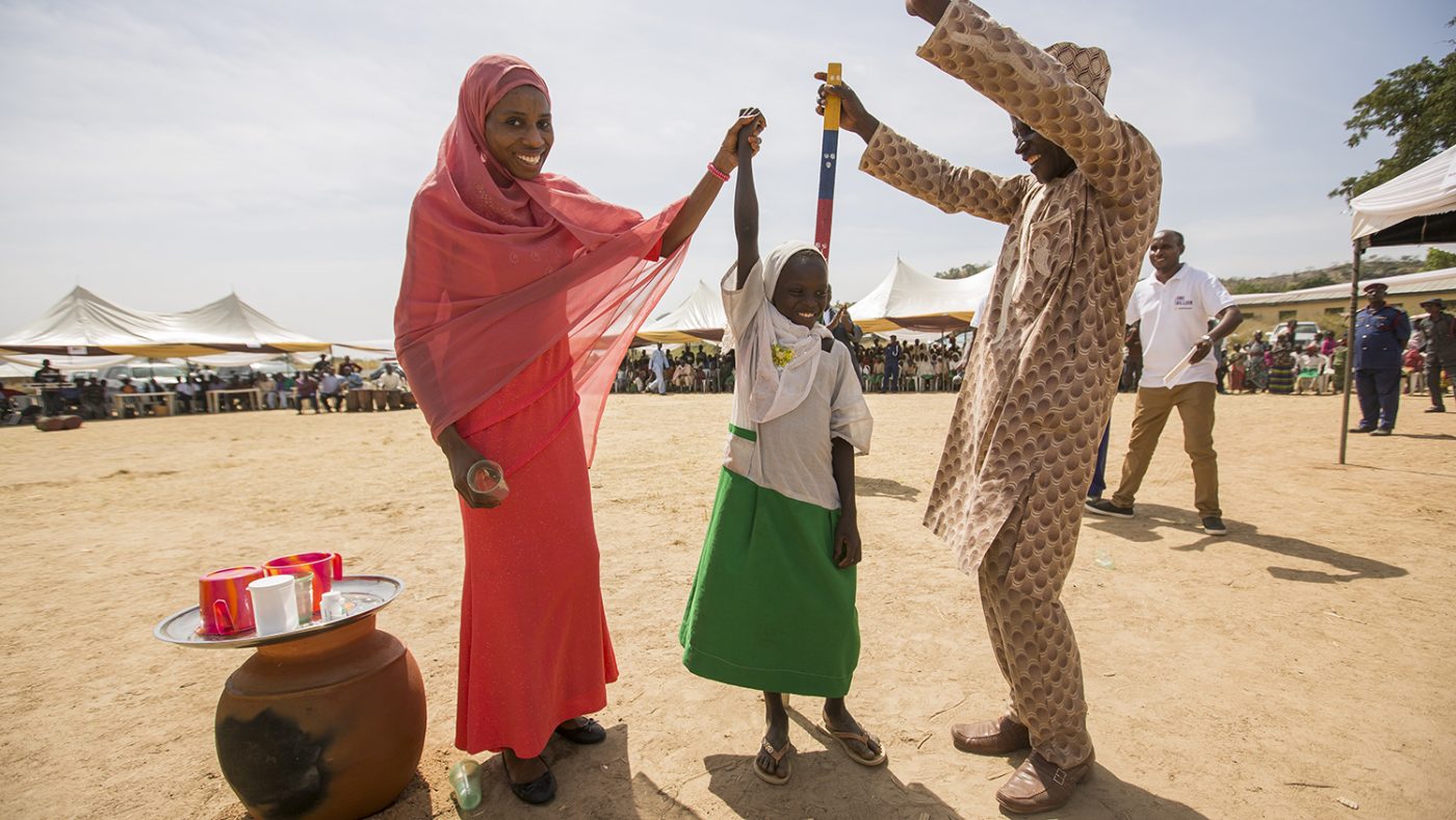 A young girl celebrates with health workers