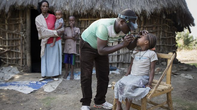 A health worker screens a child's eyes