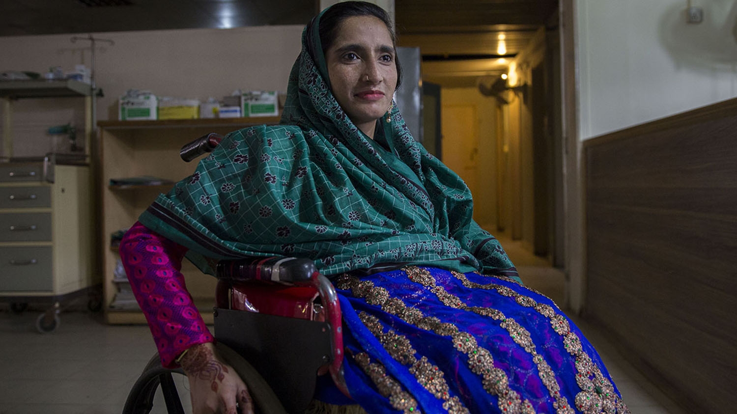 Gulnaz, who is using a wheelchair, leaves a rehabilitation centre in Islamabad.