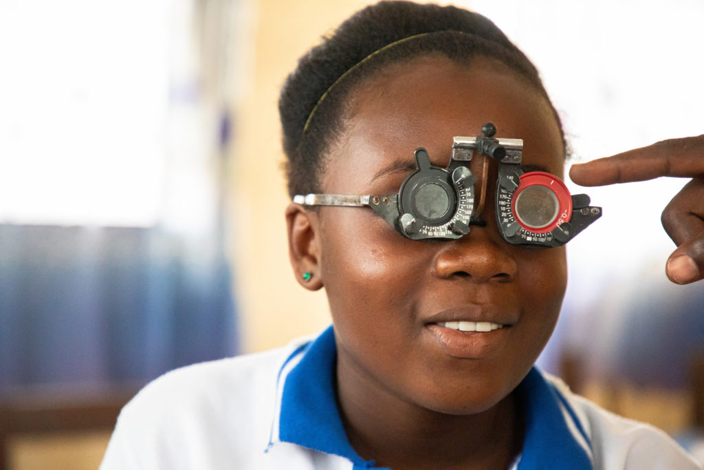 A close up of a girl shown having her eyes checked.