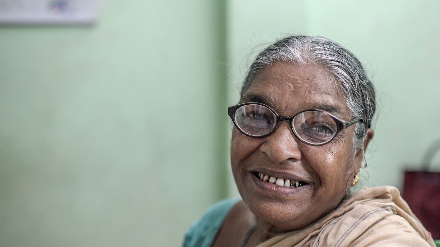 Monimala smiles while wearing glasses during an eye exam in the Sundarbans.