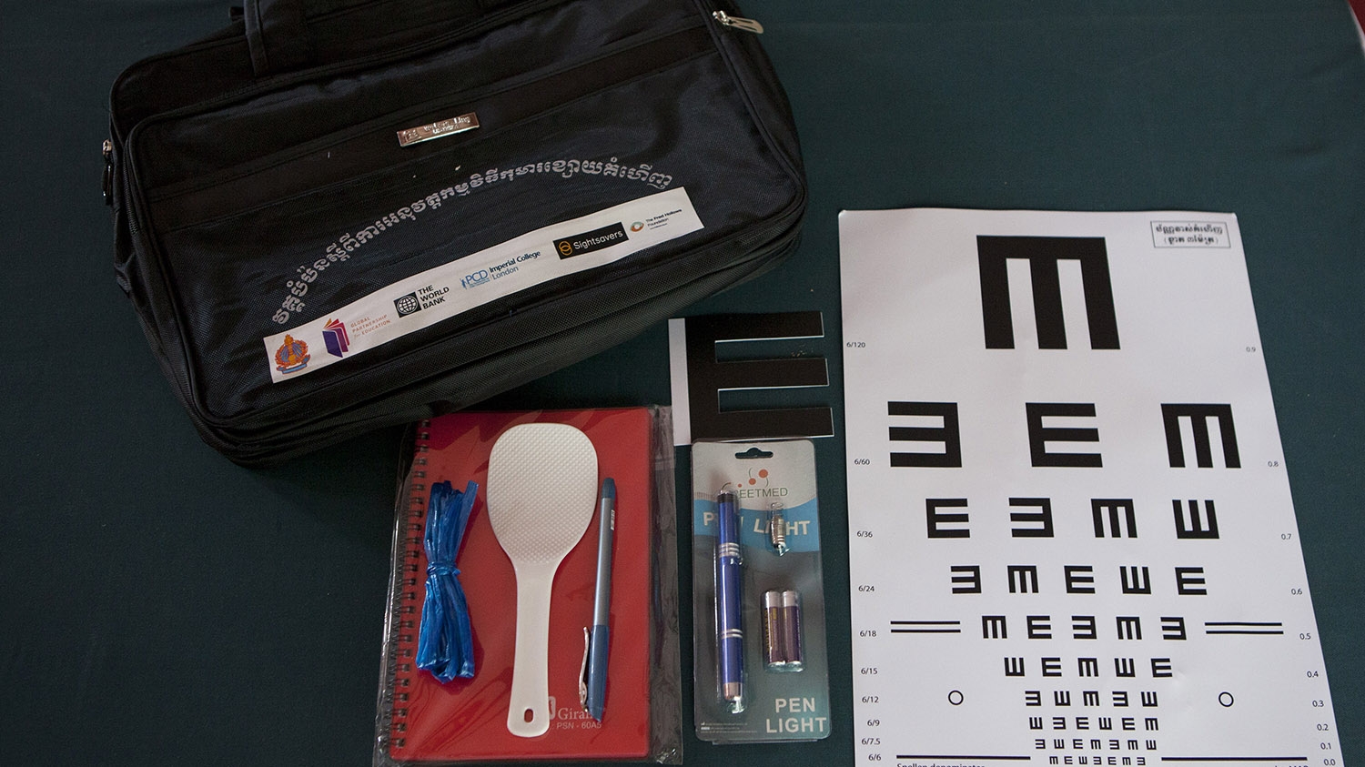Eye examination equipment, including a chart, laid out on a table.