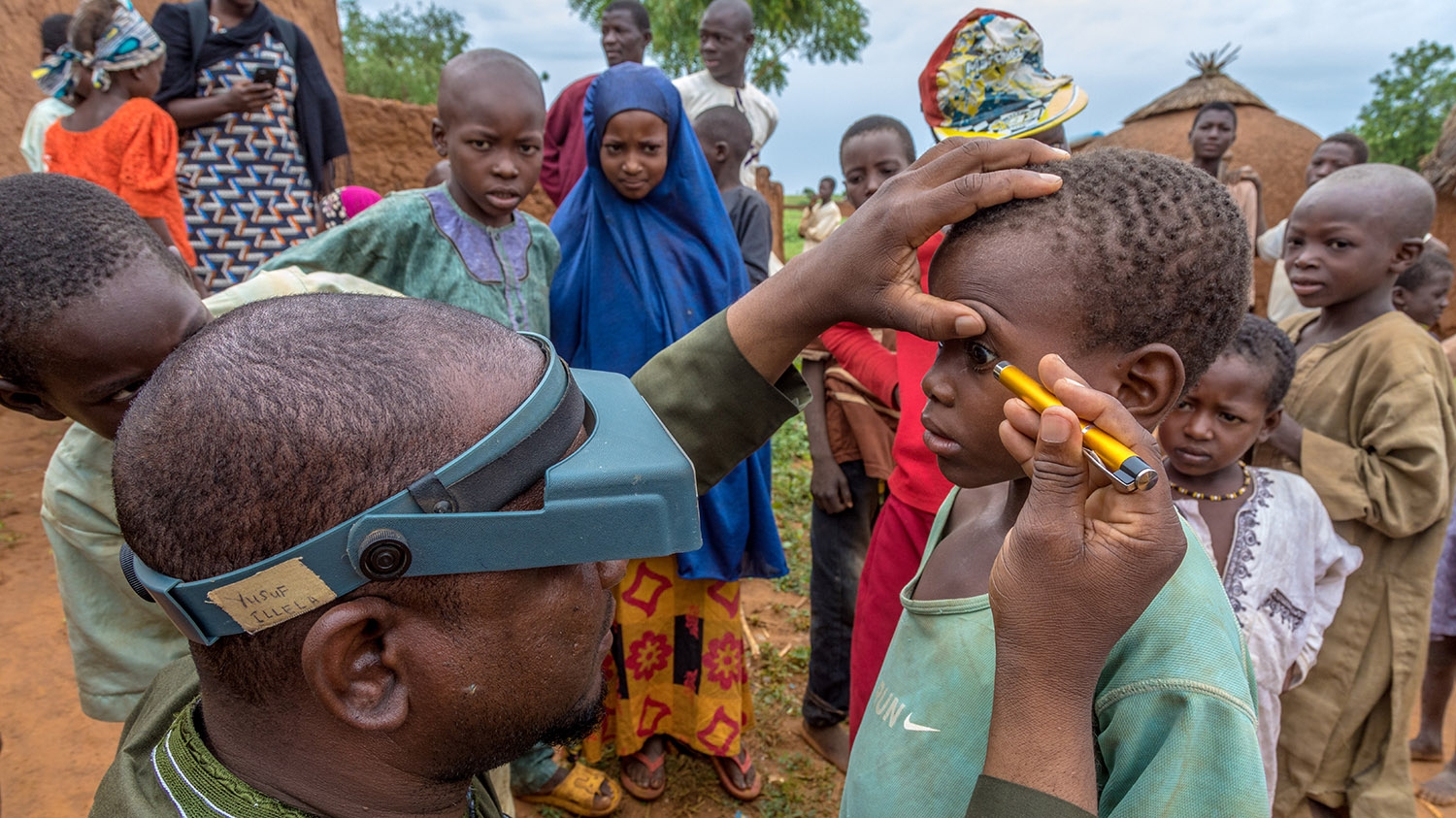 Ophthalmic nurseSuraju screens community members' eyes for trachoma.