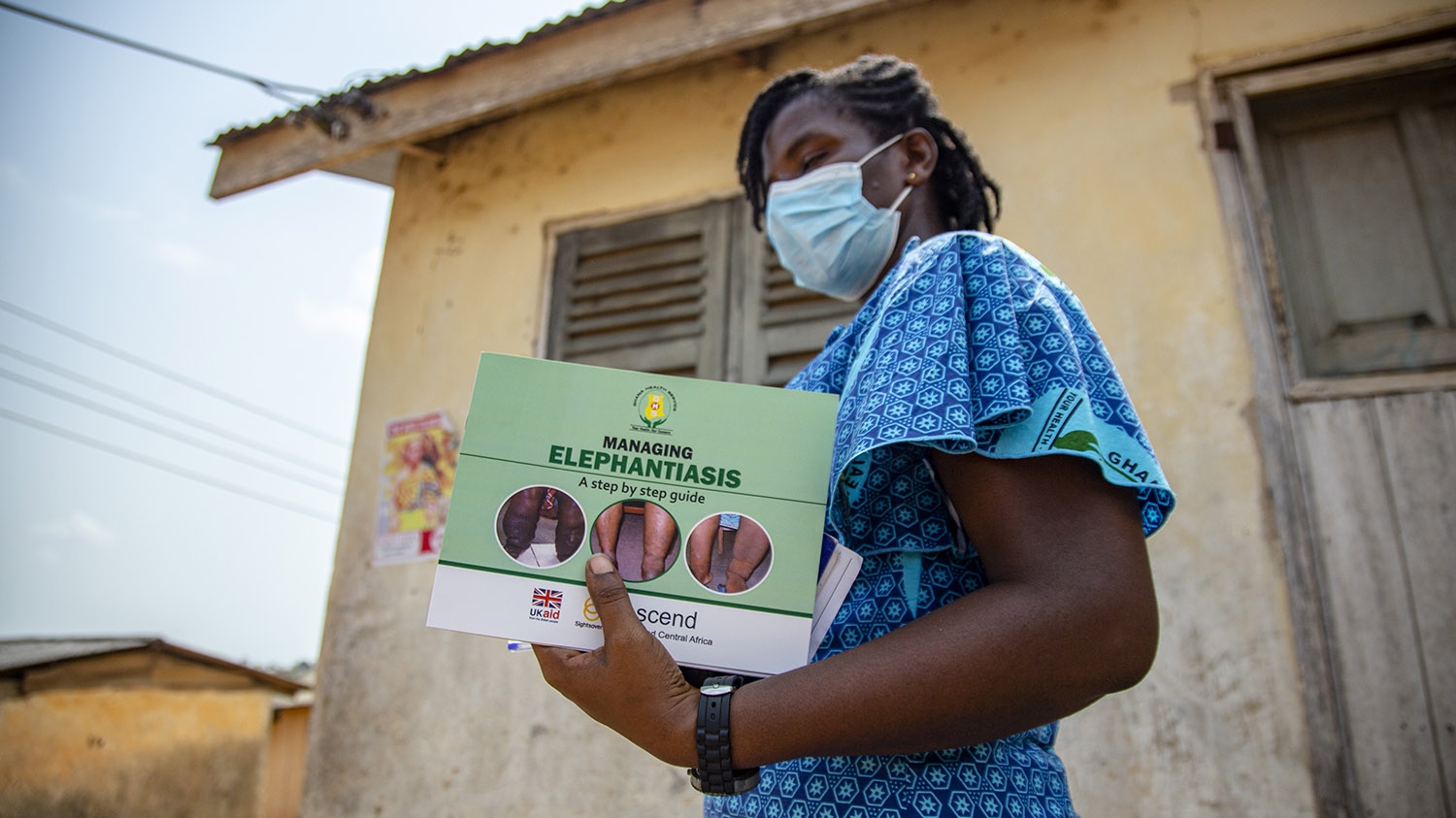 Patient, a health worker, carries leaflets on elephantiasis.