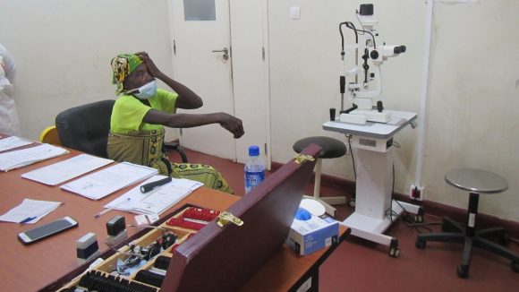 A woman takes part in an eye test surrounded by specialist eye equipment and tools.